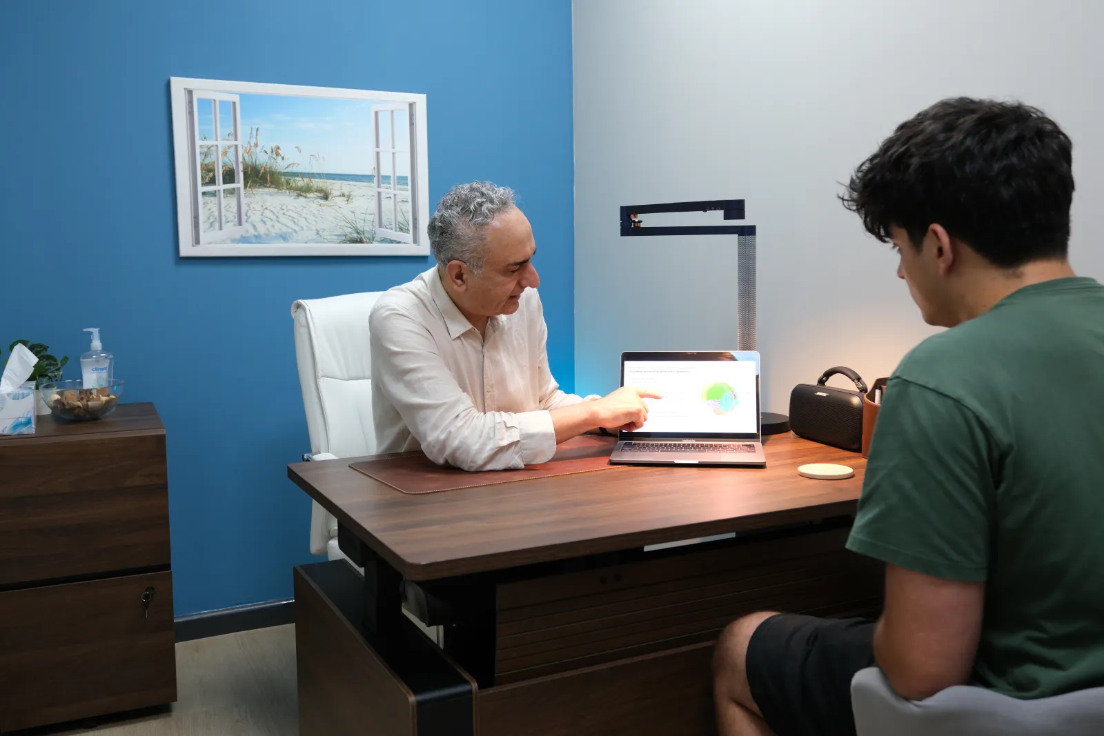 Dr Behrouz Nabavi reviewing a patient history during a consultation