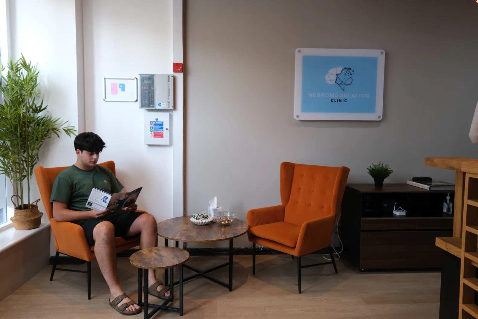 A patient reading in the clinic waiting area before an appointment